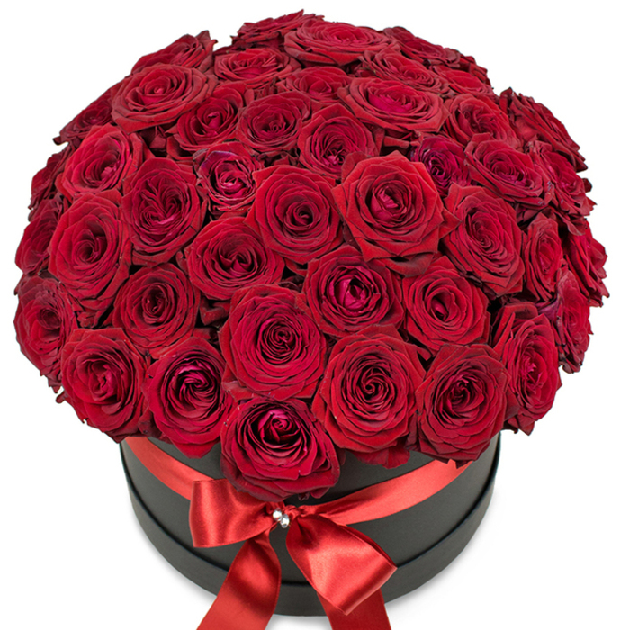 Radiating warmth and drama, this premium rose arrangement showcases the artistry of Mill Hill's most trusted florists. Each of the many deep red roses-velvety, fresh, and perfectly formed-is arranged by hand to create an abundant sphere that nearly spills from its chic matte black circular hatbox. The varying stages of blooming, from delicately furled centers to petals gently curving outward, add textural intrigue and a sense of living beauty. The visual strength of the intense scarlet blooms is further enhanced by the bold matte box beneath, its contemporary flair adding to the elegance. Encircling the base, a sumptuous red satin ribbon is meticulously tied into a large, symmetrical bow, with the knot accented by a sparkling crystal brooch, evoking a sense of high-end glamour found in the boutiques of Mill Hill Broadway. The composition, placed against a clean white background, ensures the colors remain the focus. This lavish bouquet is more than a floral gift-it's a message of profound love, perfect for special occasions such as birthdays, anniversaries, or as an unforgettable gesture of romance, designed with the exceptional care and local touch known throughout Mill Hill and the NW7 postcode.