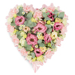 A large pastel heart of flowers is shown against a brilliant white background, its carefully arranged blooms forming a serene sympathy tribute that would sit beautifully at a funeral or remembrance gathering in Mill Hill. The heart's outline is clearly defined by a thick border of pale pink carnations, laid so closely together that their ruffled petals create a soft, cushioned edge around the entire shape. Tracing this border is a pale pink satin ribbon, glimpsed along the sides and tied into graceful bows at both the upper curve and lower tip of the heart, lending a refined, ceremonial touch. Filling the centre is a lush mixture of blossoms in gentle hues. Pink lisianthus, with their delicate, layered petals, provide focal blooms across the heart, while clusters of creamy ivory and buttery-yellow spray roses nestle between them, adding warmth and subtle brightness. Scattered throughout are tiny white daisy-like flowers with sunny yellow centres, evoking the charm of a country garden and bringing lightness to the composition. Eucalyptus sprigs, with round, silvery-green leaves, weave through the blooms, complemented by deeper green foliage that gives depth, contrast, and a sense of natural abundance. The flowers appear fresh and thoughtfully placed, as if arranged that day by a skilled florist near Mill Hill Broadway, ready for respectful delivery to a service or family home. The overall impression is one of gentle dignity and heartfelt care, a floral heart that symbolises enduring love, remembrance, and quiet support for bereaved families in and around Mill Hill.