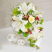 A luxurious floral design stands poised on a pure white surface, set against a warm beige background that evokes the calm, neutral tones of stylish Mill Hill interiors. At the heart of the bouquet, stately white Oriental lilies unfold their broad, velvety petals, each bloom marked with subtle speckles and long stamens that add both height and visual interest. Close by, a single tightly swirled yellow rose glows softly, its creamy petals layered in a perfect spiral like a miniature sunset over the greenery surrounding Mill Hill Park. The palette remains thoughtfully restrained, with clouds of white baby's breath threading through the arrangement to create a misty, romantic softness well suited to wedding ceremonies or vow renewals. Between these delicate sprays, near-spherical tufts of bright green dianthus sit like plush moss balls, their distinctive, almost fuzzy texture playing against the lilies' smooth surfaces. Fine, feathery foliage and slender, spiky greenery run through the design, contributing natural movement and giving the impression of a bouquet crafted from the freshest flowers brought straight into Mill Hill from local markets. Here and there, glossy red hypericum berries appear in small clusters, their deep red tones providing lively contrast and a hint of festive charm. On the right-hand side of the composition, a cascading line of white Phalaenopsis orchids tumbles elegantly downward, each flower perfectly formed with hints of yellow at the centre and accompanied by firm green buds that add promise of more blooms. The arrangement rests in a subtle white woven basket, its pattern reflected in two white wicker spheres set thoughtfully on the table beside it, reinforcing the modern yet timeless aesthetic. It feels like a centrepiece ready to grace a Mill Hill wedding reception, an upscale dinner party, or a meaningful celebration at home.