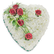 A tender, heart-shaped memorial wreath crafted entirely from hundreds of small, snow-white chrysanthemum blooms forms a pillowy, cushion-like surface that reads as quiet and pure. The dense chrysanthemums are arranged so tightly their rounded faces create a seamless, cloud-soft texture across the heart, the kind of foundation that invites a hand to rest and remember. From the upper left a graceful diagonal spray of deep, velvety red roses spills inward - three roses clustered closely with glossy, broad leaves and airy, fern-like fronds, their scent gently warming the otherwise cool white composition. Two single red roses punctuate the design: one tucked near the upper right curve and one at the heart's lower point, each framed by subtle green blades that arc like a careful, sympathetic gesture. A narrow emerald-green satin ribbon trims the heart's perimeter, giving the piece a defined, respectful edge while the polished ribbon sheen catches soft, overhead light and adds solemn elegance. Small touches of delicate white filler and thin bear-grass strands lend movement and a hand-crafted finish, the foliage's deep green offering a steady visual anchor. The overall effect is calm, dignified and intimate - a traditional sympathy arrangement meant to convey love, respect and remembrance. As a local Mill Hill florist might say, this is the kind of tribute often chosen for services at nearby chapels or for delivery to family homes around Mill Hill Park and Mill Hill Broadway, where simple, quiet gestures of condolence are appreciated.