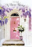 A gentle, welcoming atmosphere surrounds this Mill Hill doorway, styled as though it awaits the arrival of its new owners. Cascading from above, wisteria falls in generous clusters of lavender and lilac, creating a soft floral canopy that frames the entrance with romantic charm. The blossoms stand out against whitewashed walls, whose light, slightly textured surface reflects the natural daylight, similar to the bright façades seen around Mill Hill Broadway and its side streets. At the heart of the scene is a pastel pink front door, its chalky tone both playful and refined, glowing subtly as if lit from within by the promise of home. A coordinating pink shutter sits to one side, repeating the hue and giving the façade a thoughtful, curated look. On the doorstep, a weathered grey tin bucket holds an overflowing arrangement of white and cream roses, their petals full, velvety, and gently ruffled at the edges. Sprigs of soft green foliage nestle among the blooms, adding a fresh, garden-like feel that mirrors the leafy surroundings so characteristic of NW7. A pale pink ribbon encircles the bucket at its base, tied neatly into a bow that adds a final, romantic touch. The entire composition feels like a housewarming scene in waiting-flowers poised at the threshold, ready to greet someone moving into a cherished new address in Mill Hill, offering quiet congratulations and a beautifully scented promise of welcome home.